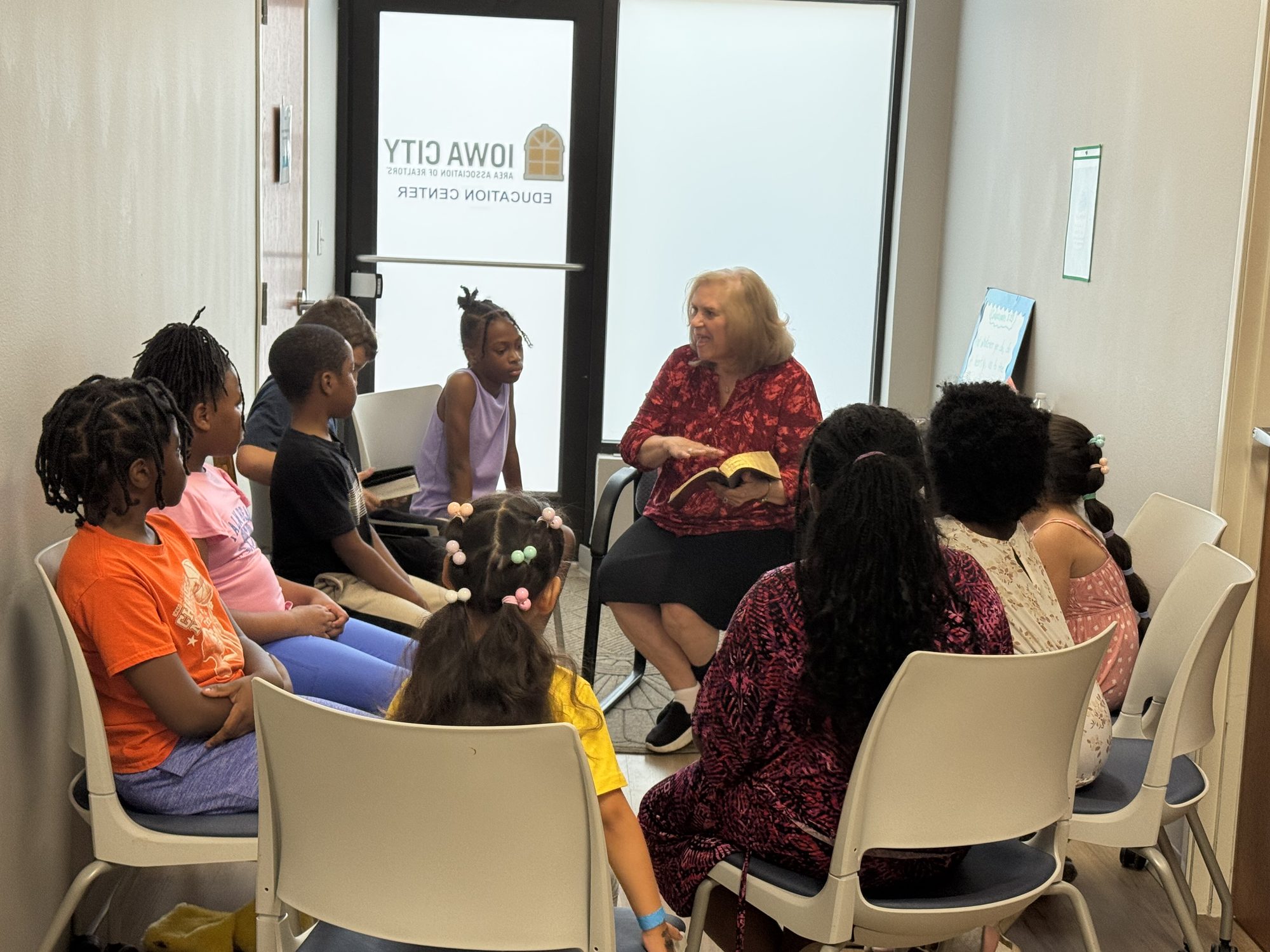 A teacher opening the Bible with children at Crosspoint Baptist Church in Iowa City
