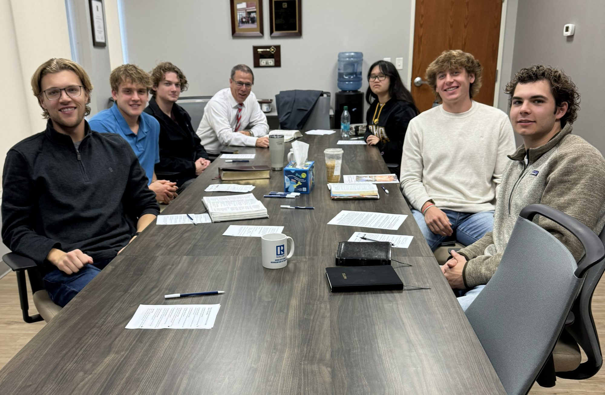 College students and singles around a table for Bible study at Crosspoint Baptist Church