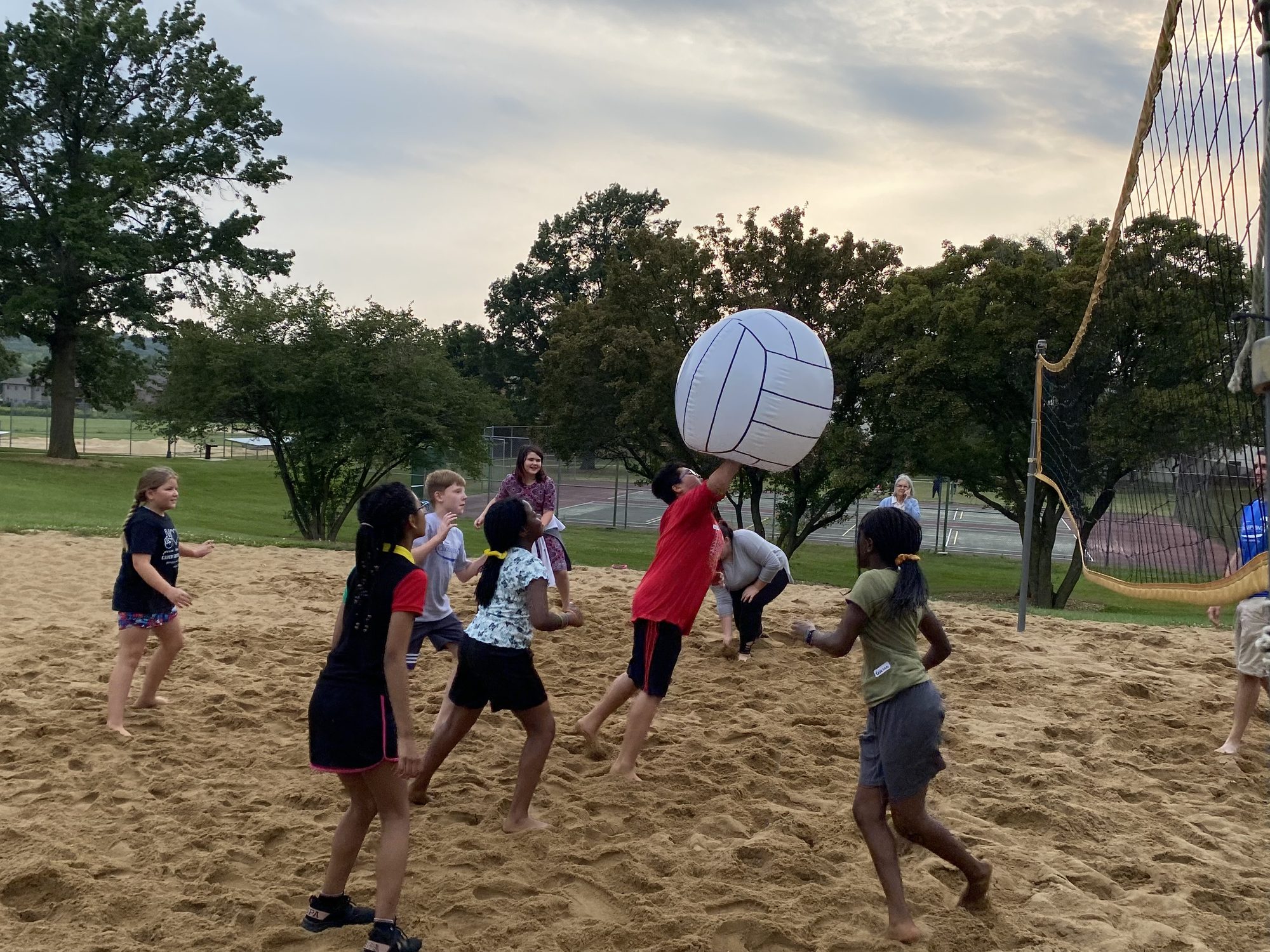 Crosspoint teens playing sand volleyball together at a park in Iowa City